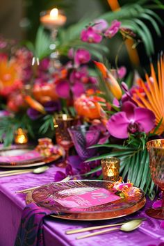 the table is set with purple and orange plates, silverware, and tropical flowers