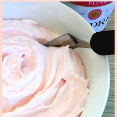 a bowl filled with whipped cream next to a spoon