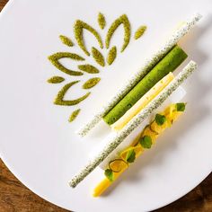 a white plate topped with three different types of food on top of a wooden table