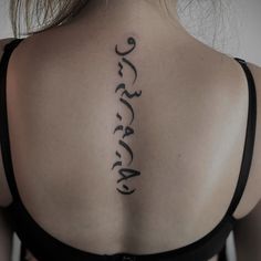 the back of a woman's neck with arabic writing on it