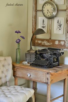 an old fashioned typewriter sitting on top of a wooden desk next to a chair