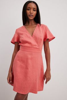 This mini dress is made of linen and features a flowy fit. It has a v neckline with an overlap detail and an open back design with a self-tie knot, a button closure at the back of the neck and an elasticized seam. Rosa Coral, Pink Linen, Future Fashion, Pink Mini Dresses, Tie Knots, Red Mini Dress, Coraline, Back Design, Na Kd