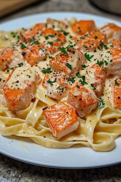 a white plate topped with pasta covered in shrimp