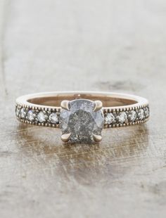 a white diamond ring sitting on top of a wooden table