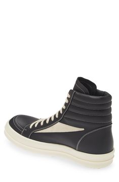 Crafted from full-grain leather and suede, this high-top sneaker is quintessentially Rick Owens with its blunted toe, dramatic lacing and shark-tooth sole. Drawing inspiration from vintage silhouettes and color schemes, this boldly topstitched shoe blends modern comfort with a timeless aesthetic. Lace-up style Leather upper and lining/rubber sole Made in Italy Designer Shoes Black Sneakers With Vulcanized Sole In Calf Leather, Black Calf Leather Sneakers With Vulcanized Sole, High-top Sneakers With Leather Sole, Custom High-top Calf Leather Sneakers With Rubber Sole, Modern High-top Sneakers With Leather Sole, Black Calf Leather Sneakers With Rubber Heel Cap, Modern Leather High-top Sneakers, Modern Calf Leather Lace-up High-top Sneakers, Sporty Custom Leather Sneakers With Rubber Toe Cap