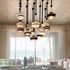 a living room filled with lots of furniture next to a large glass window covered in curtains