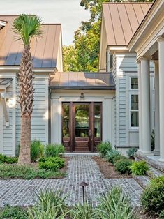 an image of a house that is in the country side with palm tree and brick walkway