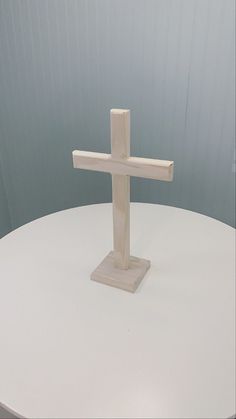 a wooden cross sitting on top of a white table