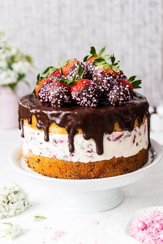 a cake with chocolate frosting, strawberries and sprinkles on top