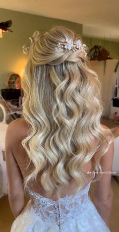 the back of a woman's head with long blonde hair and flowers in her hair