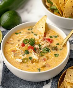 two bowls filled with chicken tortilla soup next to some tortilla chips