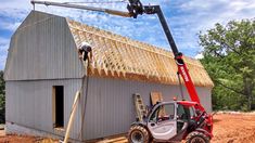 two men are working on the roof of a barn