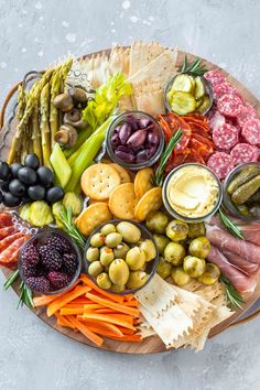 a platter filled with different types of meats, cheeses and crackers