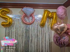 balloons and streamers are displayed in front of the backdrop