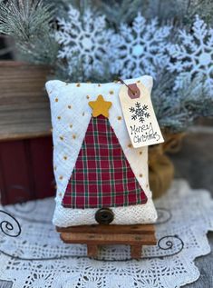 a small christmas tree sitting on top of a wooden stand