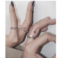 two people with matching rings on their fingers and one has a star tattoo on her left hand