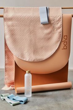 a tan bag sitting on top of a table next to a bottle and toothbrush