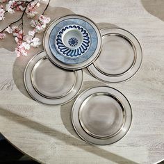 four plates on a table with flowers in the background