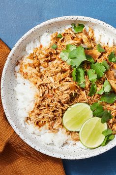 a white bowl filled with rice, meat and garnished with cilantro