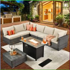 an outdoor living room with couches, tables and fire pit in front of it