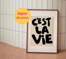 a black and white poster with the words ce'est la vie on it next to a tiled wall