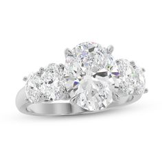 three stone engagement ring with round diamonds on the shoulders and side stones in white gold