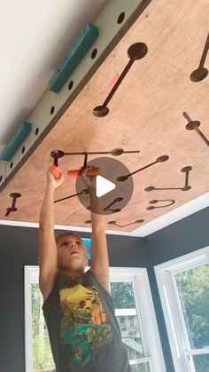 a young boy is working on the ceiling