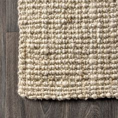 a close up view of a rug on the floor with wood floors in the background