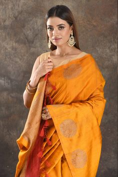 Be vision of elegance on special occasions in this mango yellow tussar Banarasi saree. The saree is enhanced with antique zari buta and pallu. It comes with a red blouse piece. Disclaimer: The actual product may vary slightly from the image. These are custom orders, hence expect slight variation in color, placement of the motif or buta. ESTIMATED DELIVERYBecause this is a custom order, it would take about 4 weeks from the date of purchase. RETURN POLICYThis product is a custom order and cannot b