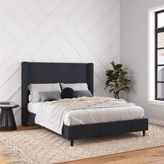 a bedroom with a bed, rug and window in the corner that has a potted plant next to it