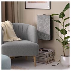 a grey chair sitting next to a plant in a living room