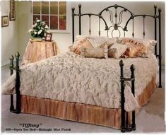 a bedroom with a metal bed frame, pillows and blankets on top of the bedspread