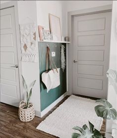 a living room filled with lots of plants and decor on the wall next to two doors