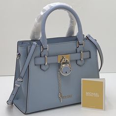 Michael Kors Hamilton Small Satchel Shoulder Crossbody Bag Color: Pale Blue New With The Tag Authentic Pebbled Leather Michael Kors Logo At Front Zip Top Closure Gold Toned Hardware Mk Key & Lock On Front Custom Mk Fabric Lining 1 Slip-In Pockets 1 Zipper Pocket 10" (L) X 8"(H) X 4"(D) Strap: 4", 18"- 24" Very Clean, Smoke-Free And Pet-Free Environment Blue Leather Bag With Lock, Blue Everyday Bag With Lock, Blue Bags With Lock For Formal Occasions, Formal Blue Michael Kors Bags, Luxury Light Blue Bags With Silver-tone Hardware, Blue Bags With Metal Hardware For Shopping, Blue Shopping Bag With Metal Hardware, Elegant Light Blue Shoulder Bag With Silver-tone Hardware, Light Blue Leather Bag With Silver-tone Hardware