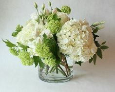 a vase filled with white and green flowers