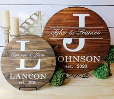 two personalized wooden signs sitting on top of a table next to candles and flowers