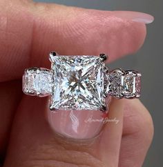 Handmade 6 CT Princess Cut Moissanite Engagement Ring in white gold. Luxury celebrity style with a large solitaire design. Perfect for a wedding ring. → Occasions: Engagement & Wedding DESCRIPTION  --------------------          STYLE              :Solitaire  ●𝐂𝐞𝐧𝐭𝐞𝐫 𝐒𝐭𝐨𝐧𝐞 𝐃𝐞𝐭𝐚𝐢𝐥𝐬 →Stone Type      :Moissanite - High Quality →Main Stone      :Princess  →Size (mm)        :10*10 →Carat Weight   :6  ●𝐌𝐚𝐢𝐧 𝐬𝐭𝐨𝐧𝐞 𝐨𝐩𝐭𝐢𝐨𝐧 𝐢𝐧 𝐂𝐓        3 CT = 7.99  x  7.99  x 5.59  MM Princess Cut Solitaire Engagement Ring, Unique Wedding Ring, Princess Cut Moissanite, Engagement Ring Unique, Engagement Ring Shapes, Princess Cut Rings, Diamond Jewelry Designs, Ring Shapes, Beautiful Engagement Rings