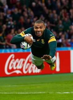 a rugby player dives to catch the ball