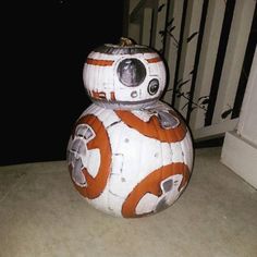 a star wars bbg pumpkin sitting on the ground in front of a stair case