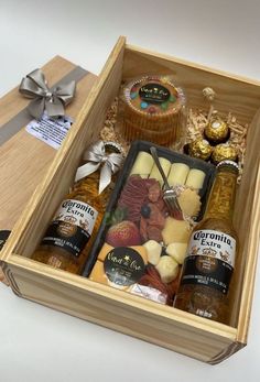 a wooden box filled with different types of food and condiments on top of a table