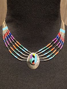 Vintage Zuni Sterling Silver Five-Strand Necklace with Multi-Stone Inlay Pendant & Matching Stud Earrings. Features a variety of materials including liquid sterling silver beads, turquoise, coral, lapis, onyx, spiny oyster, malachite, and jasper. Marked Sterling. Excellent pre-owned condition; appropriate for age. 21g total (16g necklace; 5g earrings) Multicolor Teardrop Beads For Jewelry Making, Multicolor Multi-stone Round Jewelry, Multicolor Teardrop Jewelry For Jewelry Making, Teardrop Multi-stone Jewelry Making Supplies, Multicolor Multi-stone Teardrop Necklace, Multicolor Multi-stone Oval Necklaces, Multicolor Oval Jewelry With Stone Setting, Oval Multicolor Multi-stone Necklaces, Multicolor Multi-stone Oval Necklace