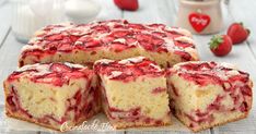 a cake that has been cut into slices and is sitting on a table next to some strawberries