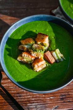 two bowls filled with food on top of a wooden table