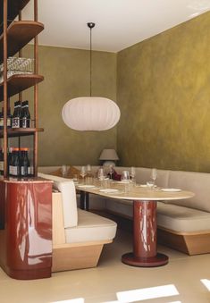 a table and chairs in a room next to a shelf with wine bottles on it