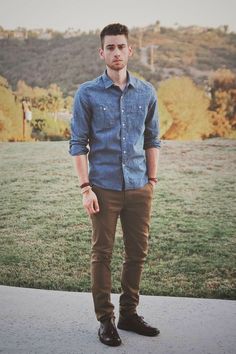 a young man standing in front of a field