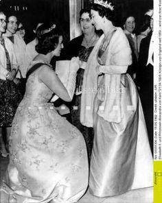 black and white photograph of women in formal dress talking to each other at an event