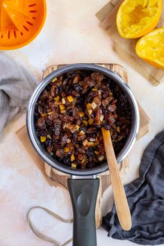 a pan filled with raisins on top of a cutting board next to sliced oranges