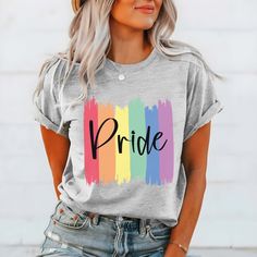 The "Pride Paint Strokes" Graphic Tee is more than just a garment; it's a vibrant celebration of diversity, love, and unity within the LGBTQ+ community. Crafted with meticulous attention to detail, this tee combines comfort with style, making it the perfect choice for expressing your pride and solidarity. The colorful rainbow paint strokes create a bold and eye-catching design, symbolizing the spectrum of identities and experiences within the LGBTQ+ community. Whether you're marching in a pride Cotton T-shirt With Rainbow Print For Pride, Trendy Rainbow Top For Pride, Trendy Multicolor Pride T-shirt, Spring Multicolor Slogan T-shirt, Spring Multicolor T-shirt With Text Print, Relaxed Fit Crew Neck T-shirt For Pride, Pride Multicolor Short Sleeve Tops, Trendy Rainbow Pride T-shirt, Trendy Rainbow T-shirt For Pride