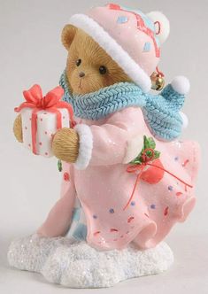 a figurine of a teddy bear holding a gift