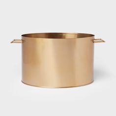 a large gold metal pot with handles on the outside and inside, in front of a white background